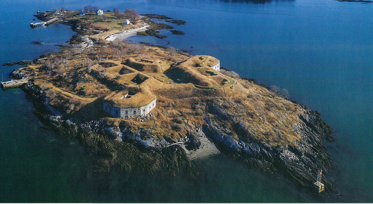 an aerial view of an hour-glass shaped island with an old stone fort