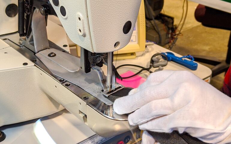 Close up of a worker at Flowfold making protective gear for health care workers 