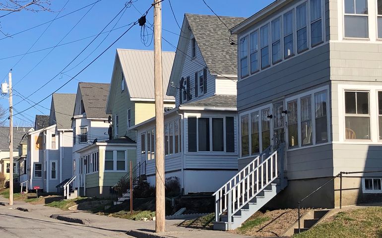 A row of two and three story apartment houses in a Maine city