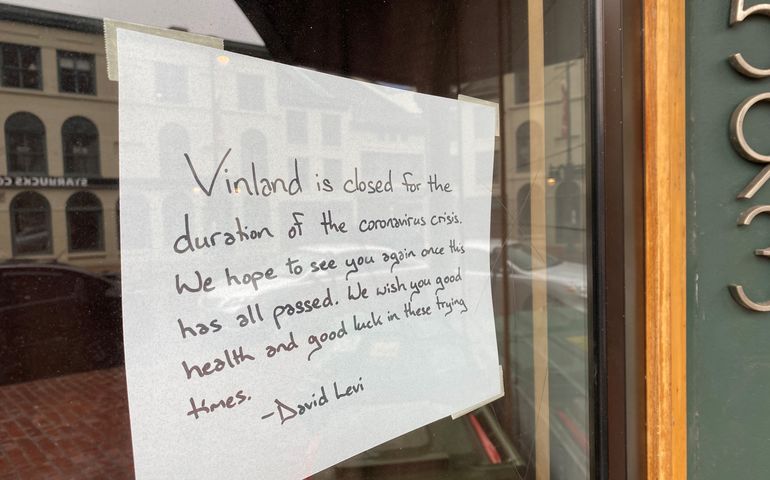 A sign in a store window that says vinland is closed for the duration of the coronavirus crisis 