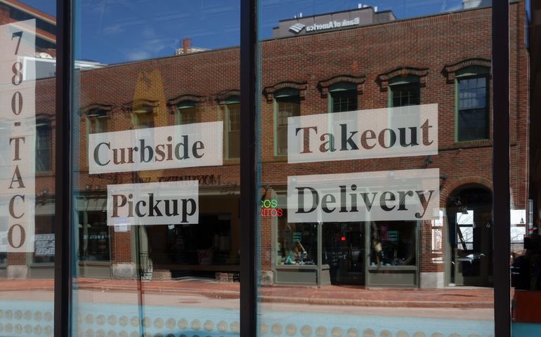 Storefront window of a food place advertising takeout 