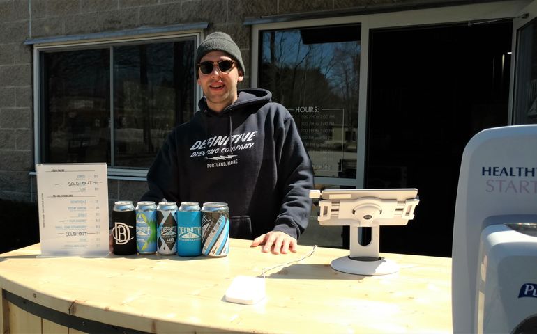 man in sunglasses behind beer counter