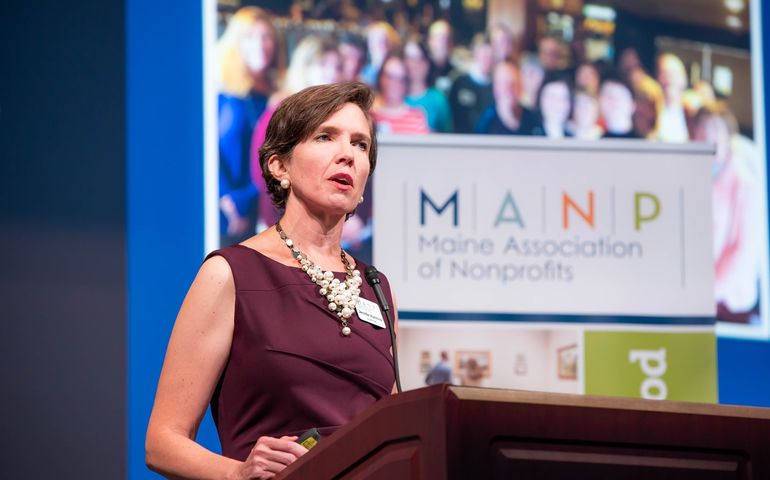 Jennifer Hutchins at a Maine Association of Nonprofits event (at a podium)