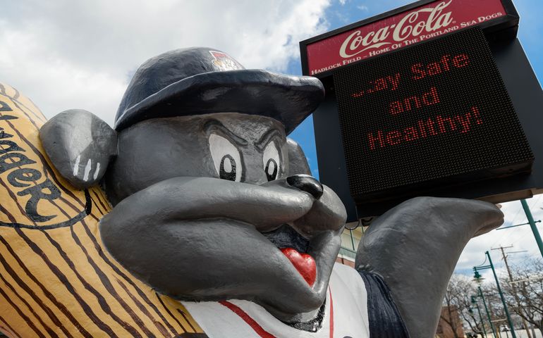 Front of Hadlock Field showing a statue of Slugger and a sign that says, "Stay Safe and Healthy!"