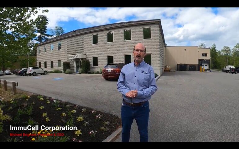 Screen shot of Michael Brigham of ImmuCell, in front of the new building, from a video.