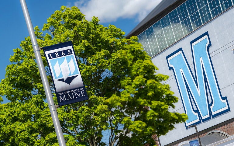 University of Maine campus shot showing building and a flag