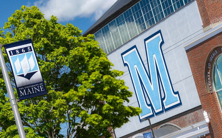 University of Maine campus shot showing building and a flag