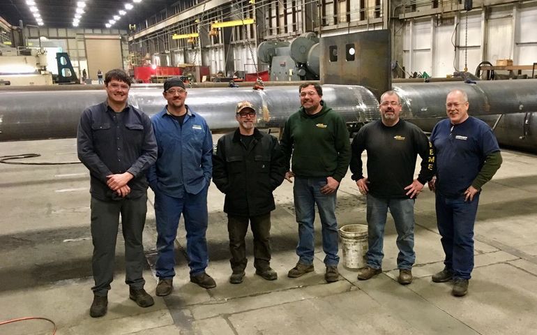 Six Downeast Machine workers assembled in manufacturing plant