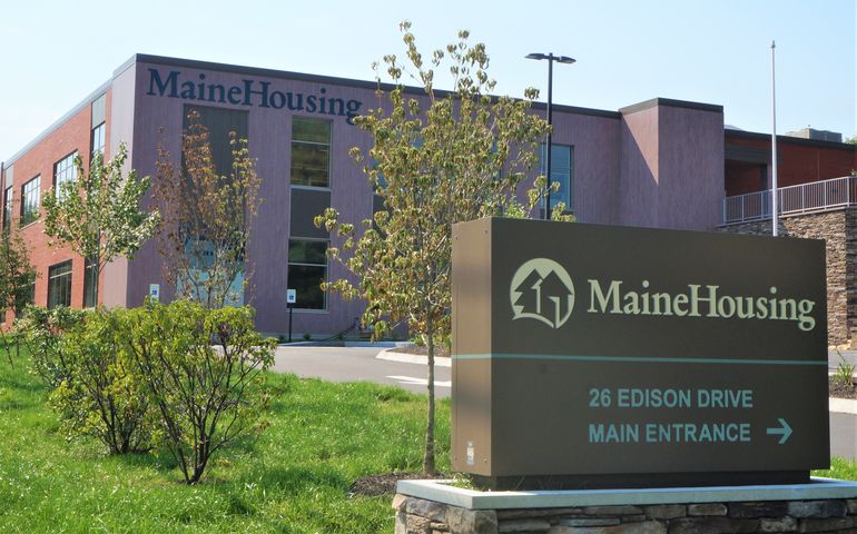 A modern building that says MaineHousing on it with a sign in front that says Mainehousing main entrance