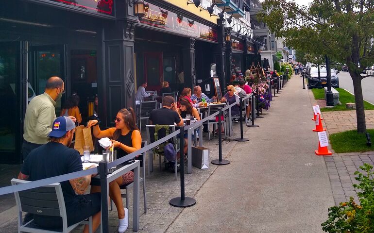 Bar Harbor sidewalk lined with outdoor restaurant tables and customers