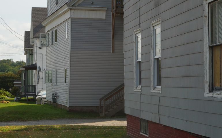 A closeup of a row of clapboard three-story houses in Augusta Maine