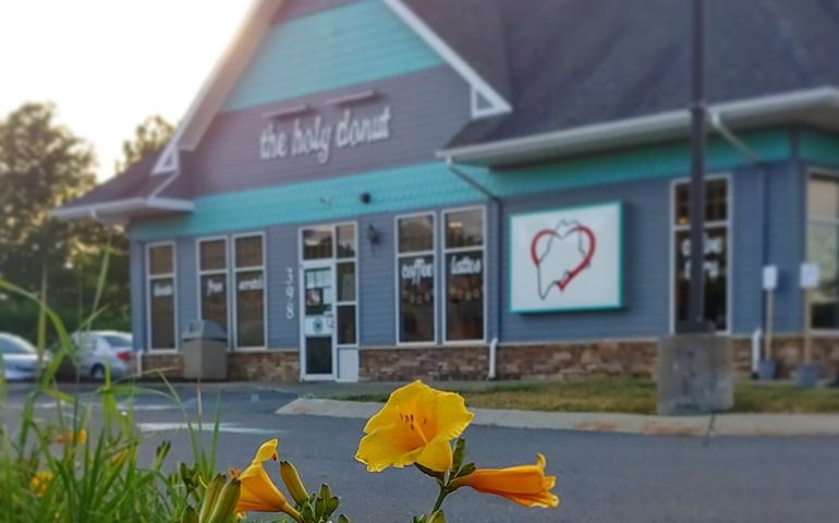 Exterior photo of The Holy Donut location in Scarborough, with daffodils in the foreground.