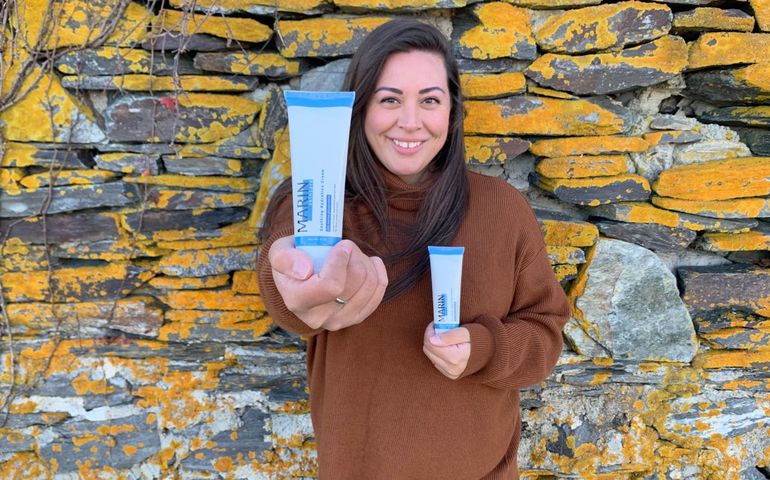 Amber Marin holds bottles of Marin skincare