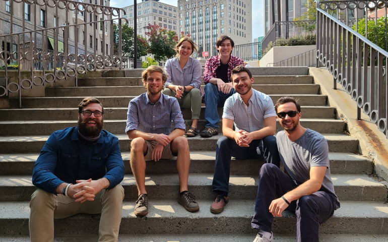 a group of five men and one woman sitting on granite steps in downtown Portland