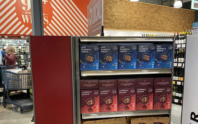 A store dispaly with Maine Crisp cranberry almond and blueberry walnut boxes on the shelves
