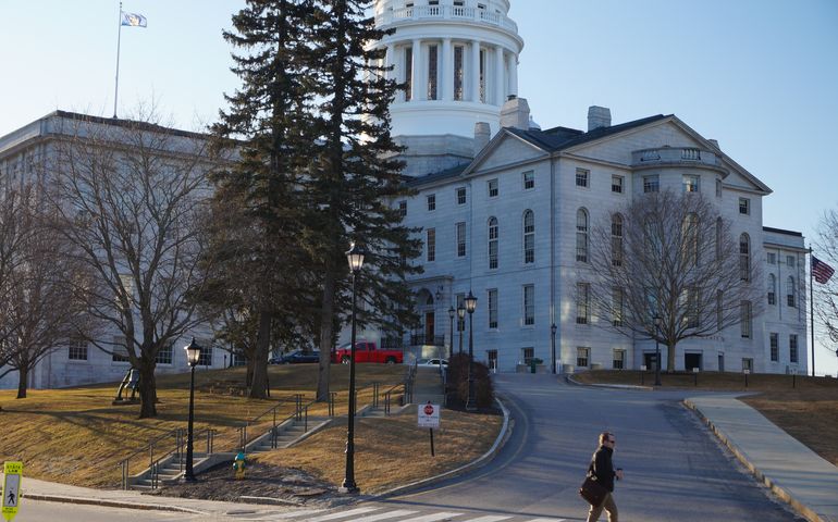 a view of a large granite building with a copper dome and steps leading up to its doors