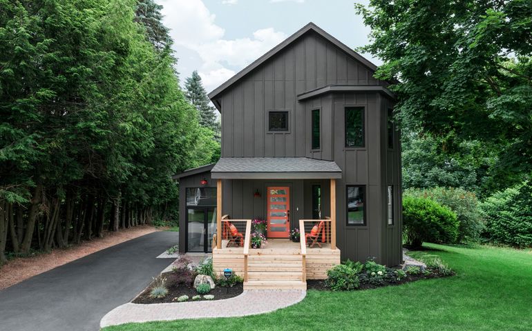 a pretty two-storty house on a green lawn