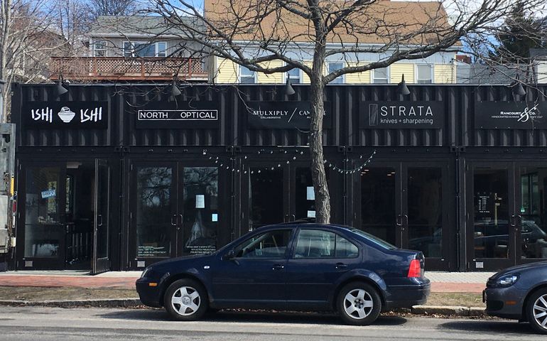 A black one-story building with five storefronts