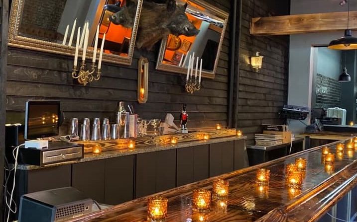 a bar in a restaurant with candles on the bar