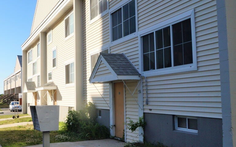 A row of small public housing townhouses with very small yards in front