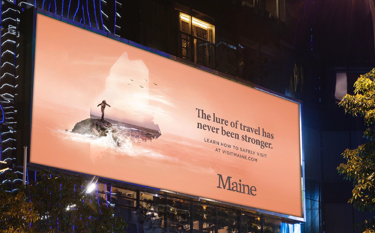 a billboard that says the lure of travel has never been stronger learn how to safely visit at visitmaine.com Maine