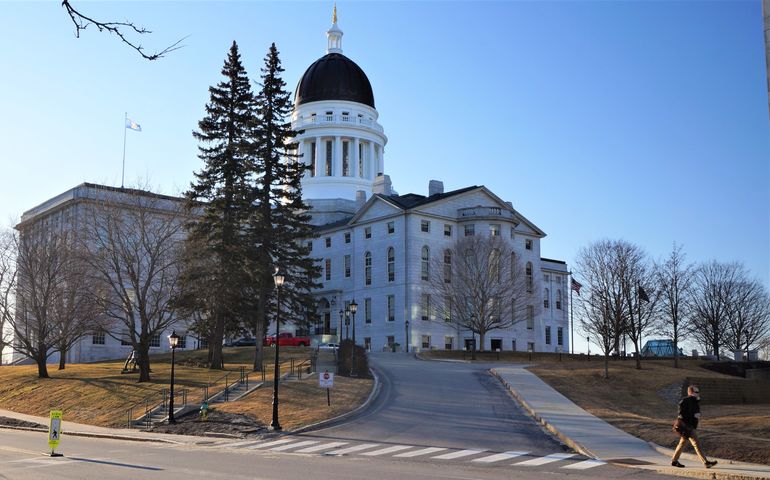 The Maine State House, rear view, a large granite building with a copper dome on top