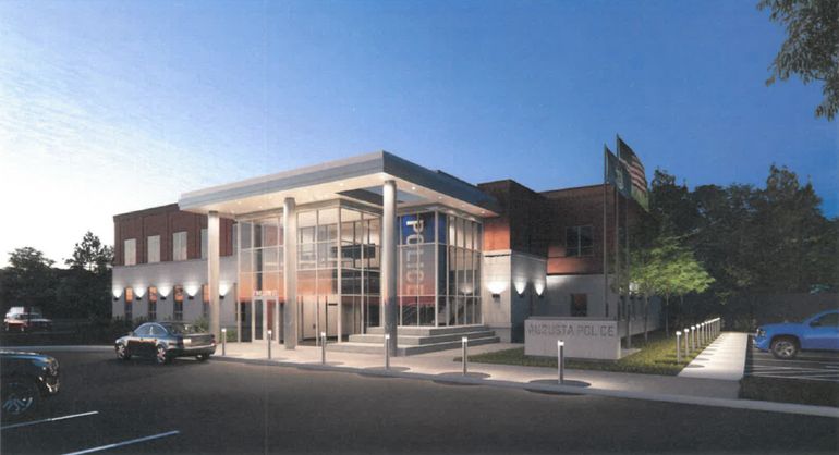 A rendering shows a modern two story building lit up at night with a glass entrance and pig sign that says police