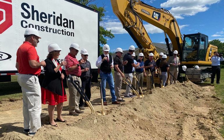 group with shovels and hard hats at construction site