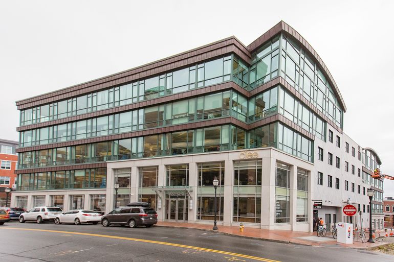 a five-story glass building on a street corner