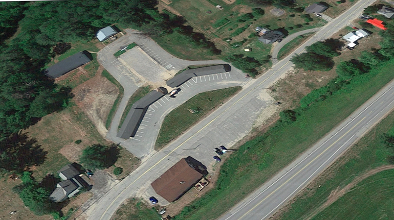 an aerial view of a motel next to a two-lane highway