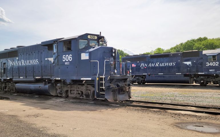 two railroad locomotives, sitting on tracks