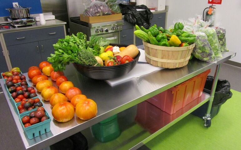 baskets of fresh produce sit on a metal table in what looks like it could be a school ktichent