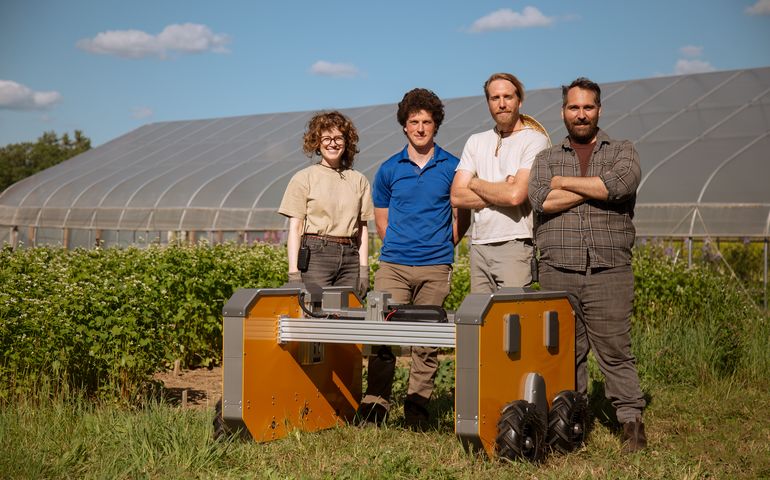 4 people with machine in field