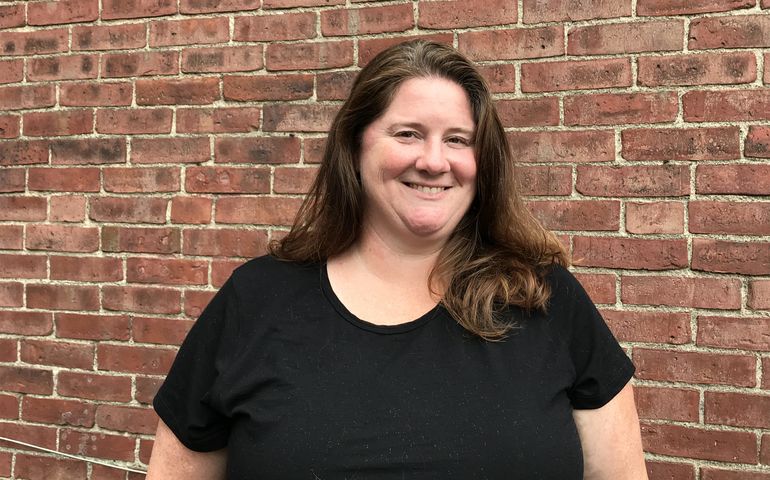 person posing and brick wall