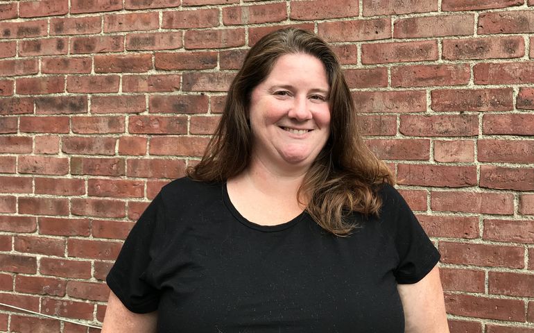 person posing and brick wall