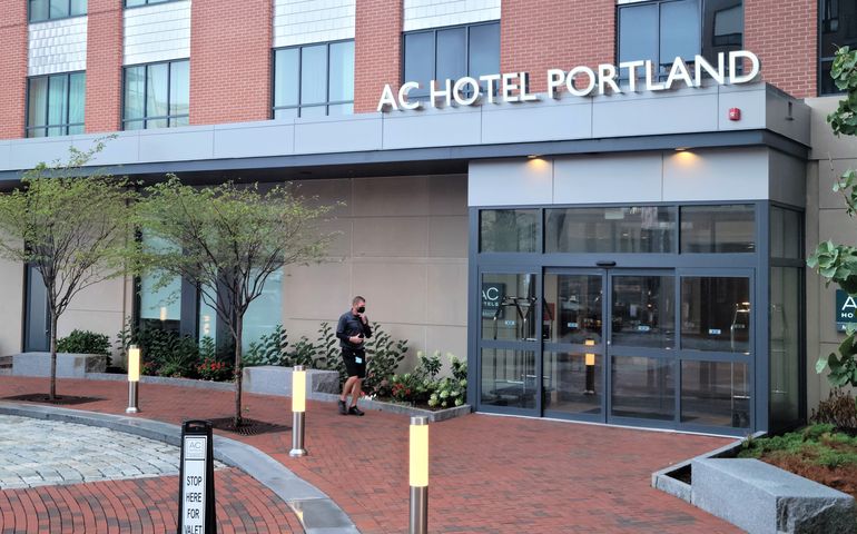 entrance to hotel, with "AC Hotel" sign and valet walking to door