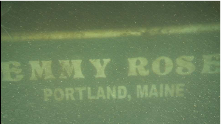 transom of fishing vessel with name "emmy rose" viewed in green water