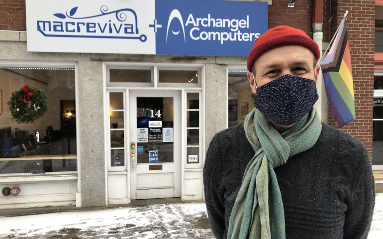 person with mask at computer store