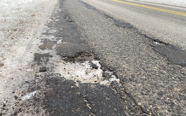 Winter street image showing pothole and a bit of snow