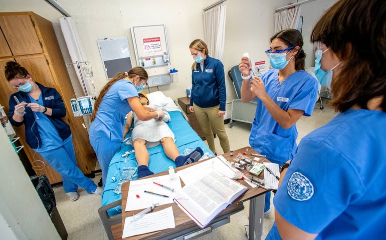 people in health care uniforms around bed