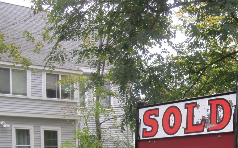 sold sign with tree and house