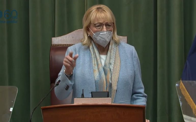 Mills speaking at podium