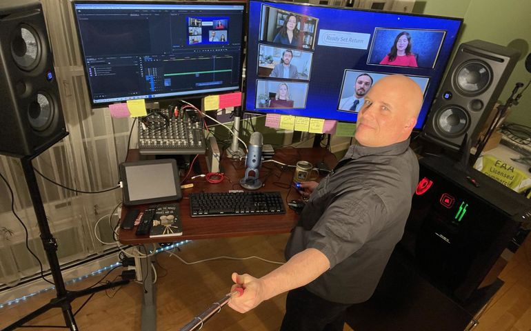 man surrounded by TV control equipment