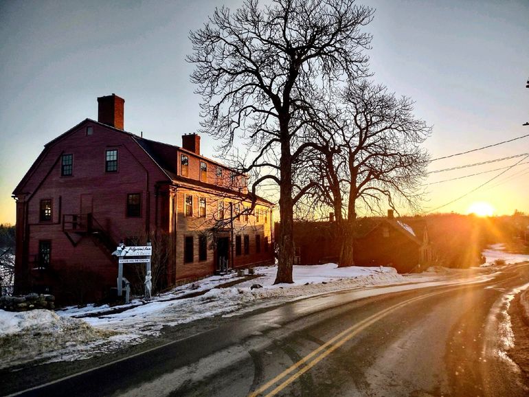 red building and sun on quiet road