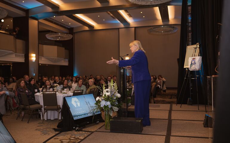 Janet Mills at a podium speaking at a conference