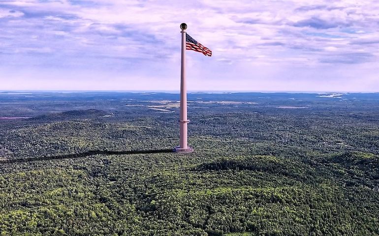aerial view of huge flagpole, surrounded by forest