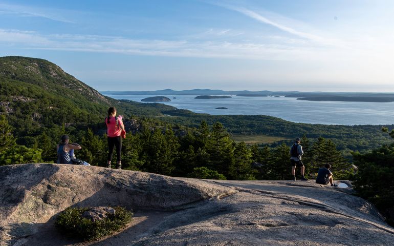 people on hill over ocean