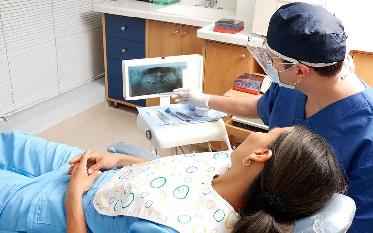 Patient with dentist, and X-ray image on the screen 
