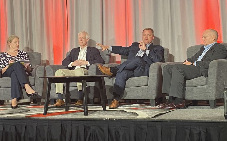 Four panelists on stage sitting down 
