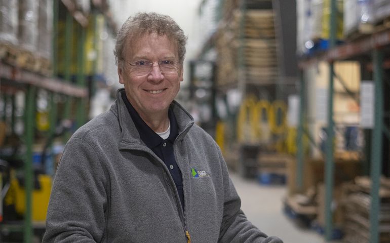 Tim Brooks in a food bank, holding a box